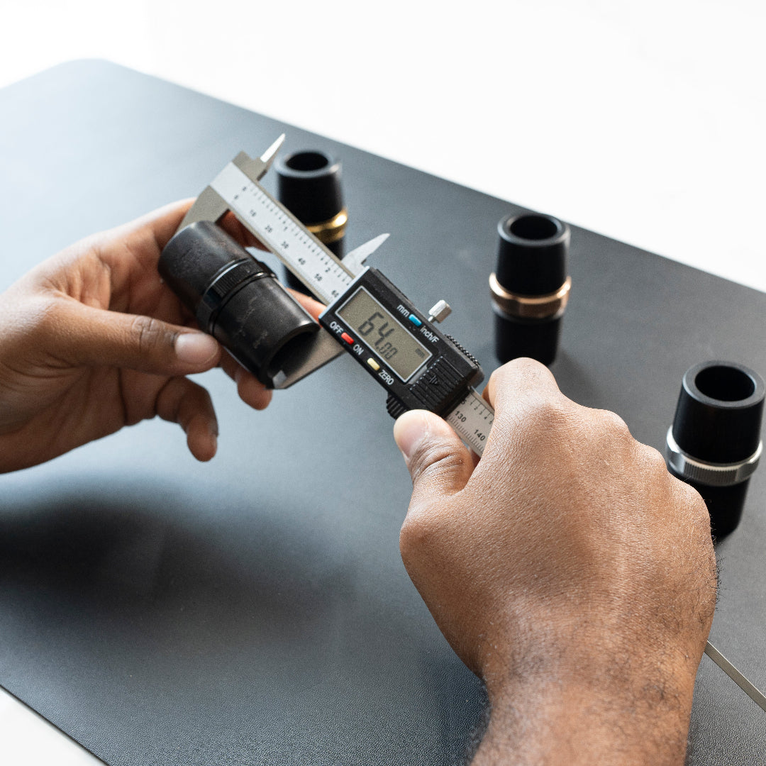 Person using a digital caliper to measure a Royal Global Adjustable Clarinet Barrel.