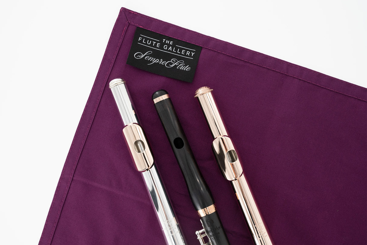 sempre|flute Cleaning Cloth - Flute Gallery, Limited Edition - two flute headjoints and a piccolo headjoint sitting on top of it.