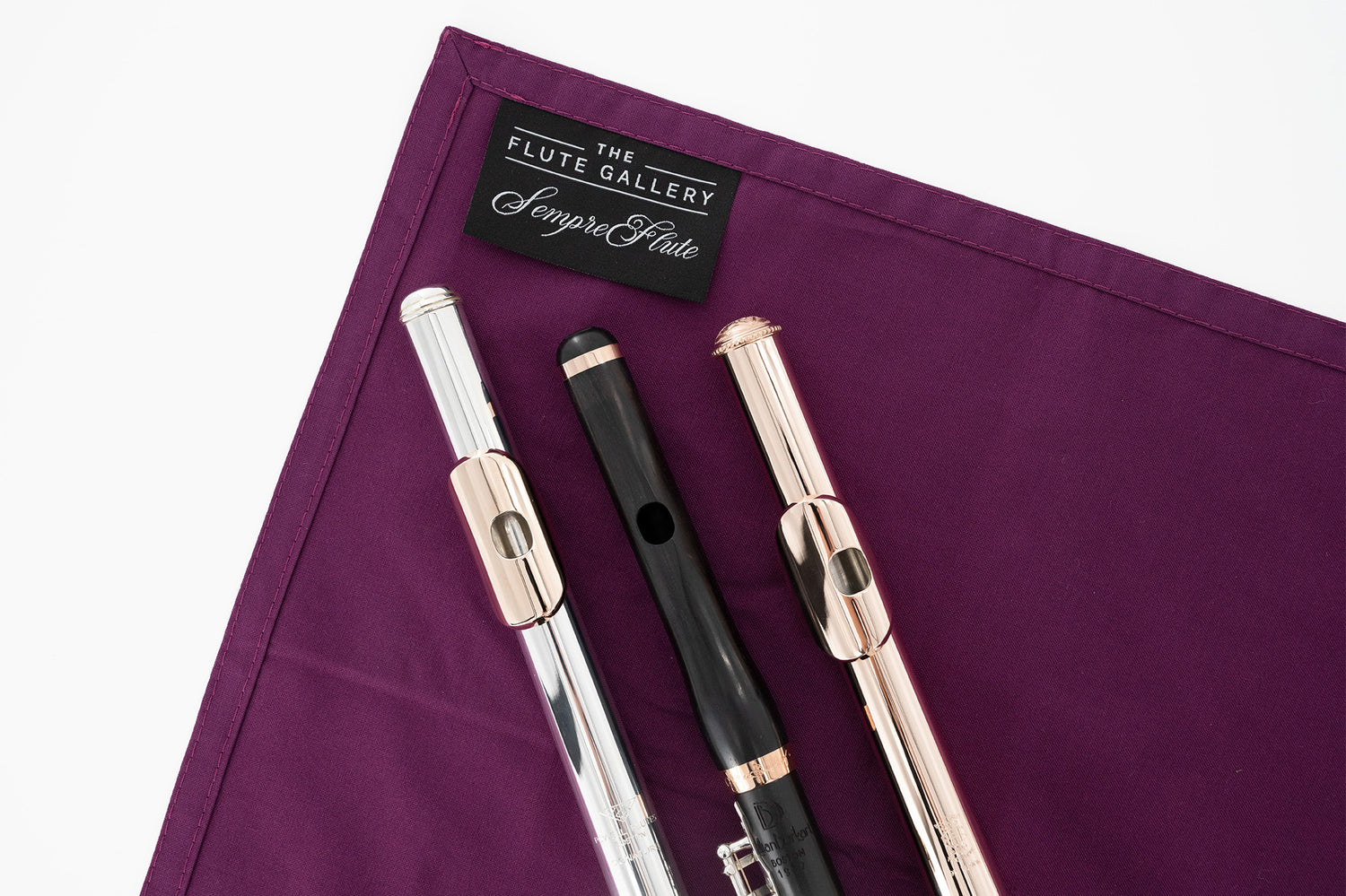 sempre|flute Cleaning Cloth - Flute Gallery, Limited Edition - two flute headjoints and a piccolo headjoint sitting on top of it.