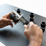 Person using a digital caliper to measure a Royal Global Adjustable Clarinet Barrel. 