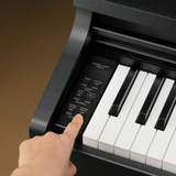 Kawai digital piano with a hand pressing a button on the control panel