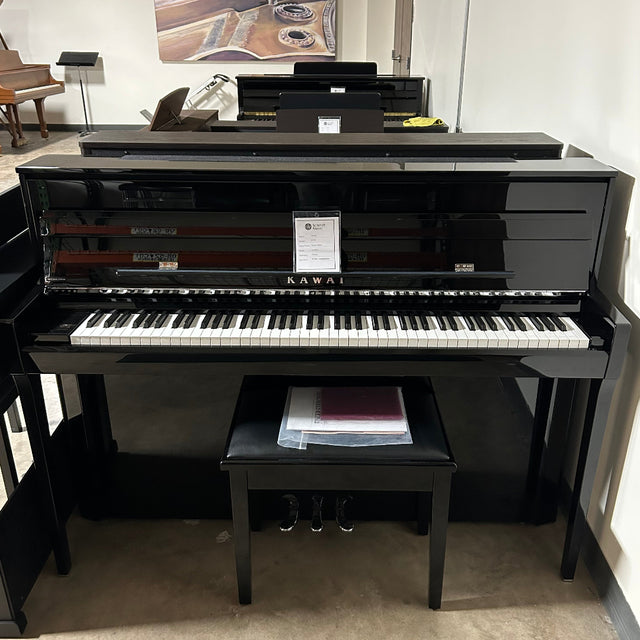 A glossy black upright piano with a matching bench in a showroom or indoor room setting.