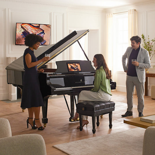 People next to a Steinway & Songs Grand Piano
