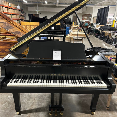 Black upright piano in a warehouse setting