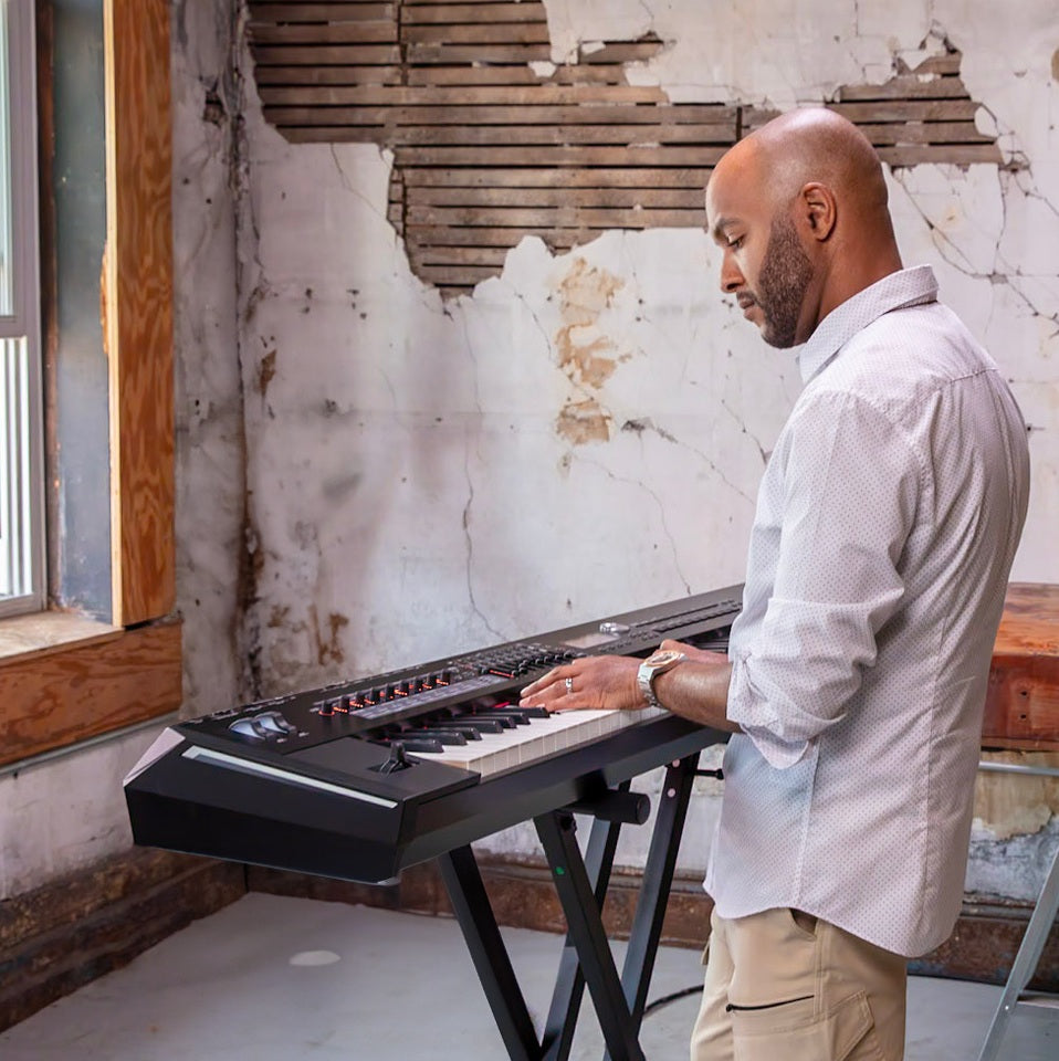 Man playing a Kawai Digital keyboard in a room with peeling paint on the walls