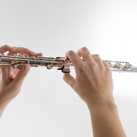 Solexa Thumbport II - C Flute - attached to a flute with hands holding the flute in playing position
